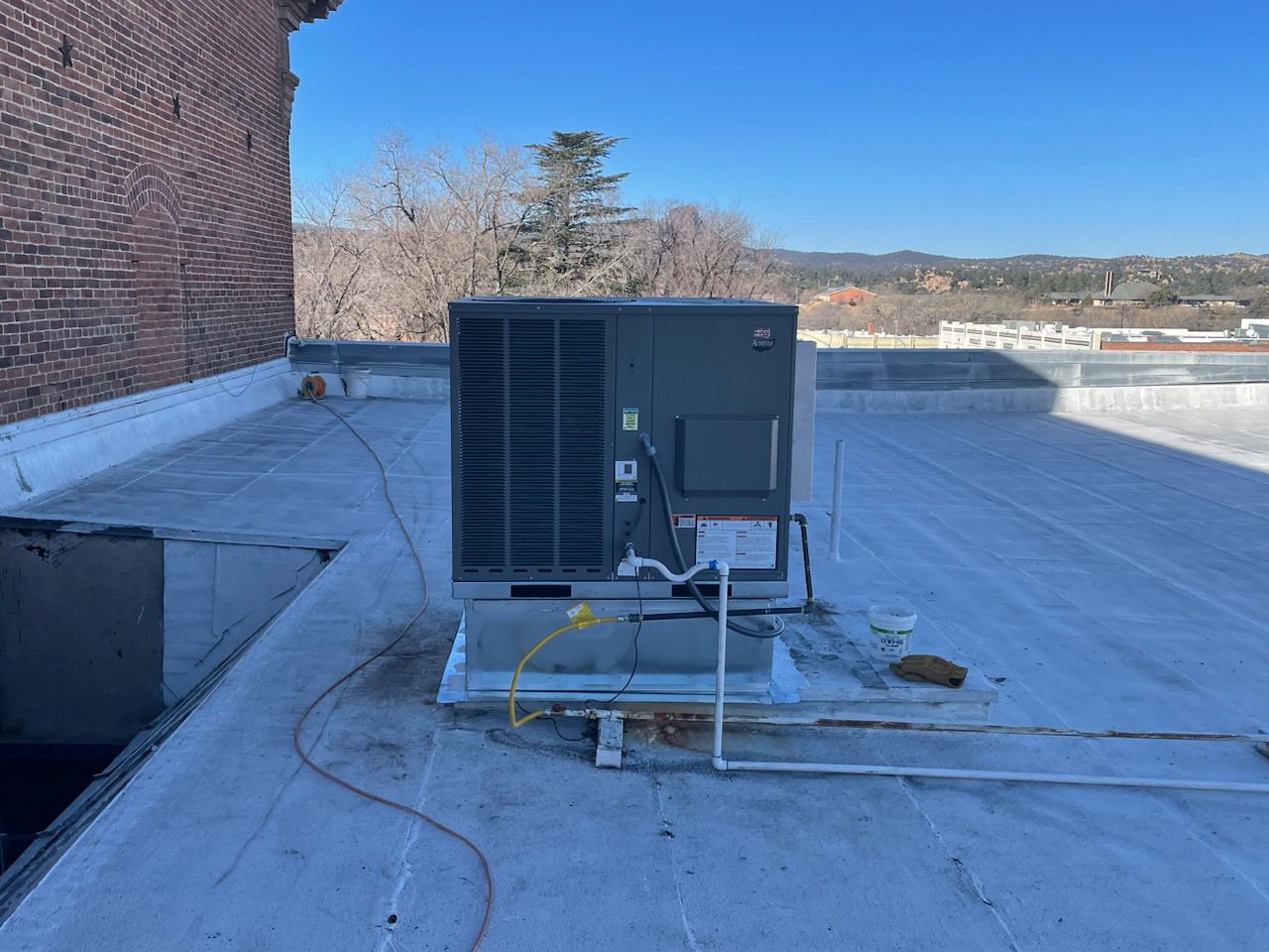 A large air conditioner is sitting on top of a roof.