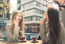 Two young women talking and drinking coffee