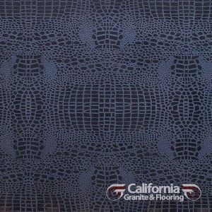 Close-up of dark blue crocodile-textured material. The intricate pattern mimics the hide of a reptile.