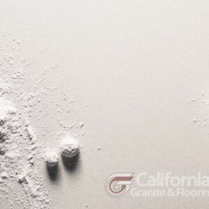 White powder and small balls on a white surface.
