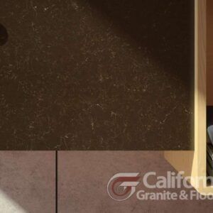 Close-up of dark granite counter and light brown floor with California Granite & Floors logo.