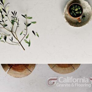 White table setting with olives, leaves, and wood slices.
