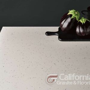 Light speckled countertop with eggplants and dark spill.