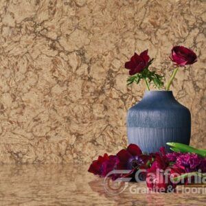 Burgundy flowers in a blue vase on a countertop with a textured beige backsplash.