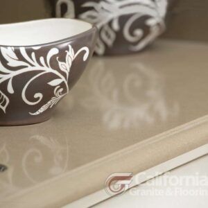 Close-up of a light-colored countertop with decorative bowls, showcasing floral designs.
