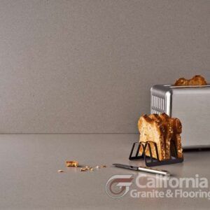 Toasted bread with crumbs and a toaster on a gray countertop.
