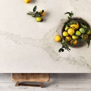 Lemons on a marble table, in a bowl and scattered. Wooden base.