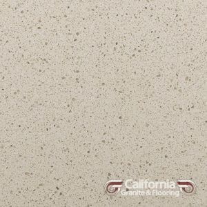 Off-white quartz countertop with small flecks of color; California Granite & Flooring logo in bottom right.