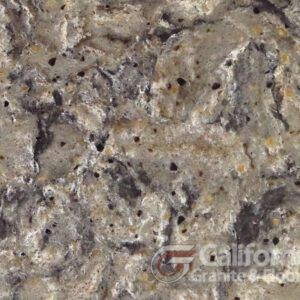Close-up of a countertop with a speckled, beige and gray marbled pattern and small dark spots.