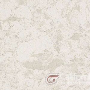 Close-up of light beige quartz countertop with scattered, mottled patterns.