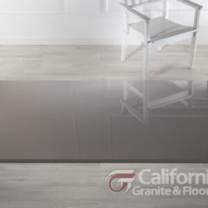 High-gloss gray floor reflecting a white chair; California Granite & Floor logo in the corner.