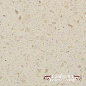 Cream-colored quartz countertop with speckled beige and tan aggregate. California Granite & Flooring logo in the bottom right.