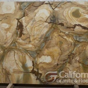 Close-up of a beige, brown, and green stone slab with swirling patterns and dark crack-like lines.