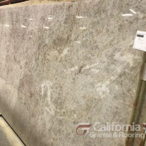 Large slab of beige granite with gray and white veining, displayed at a granite store.