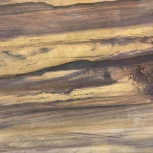 Close-up of wood grain with alternating bands of brown and yellow colors.