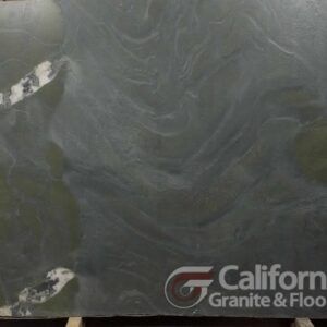 A large slab of greenish-gray stone with white veining, displayed with the