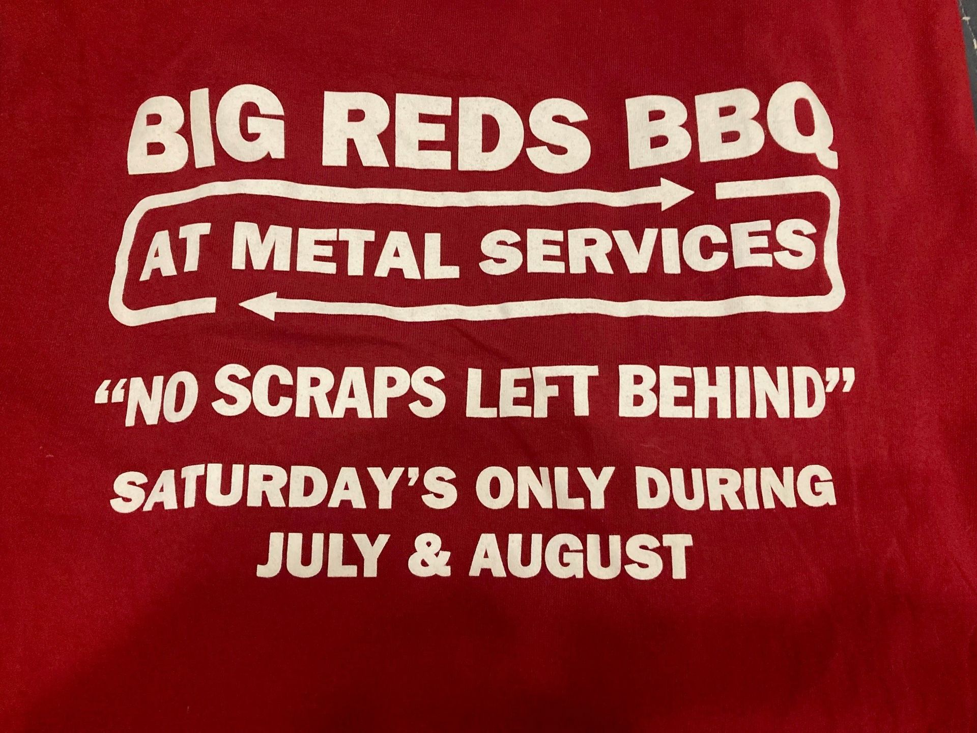 A red shirt that says big reds bbq at metal services