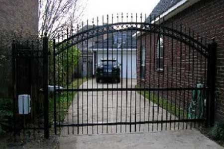 Black metal driveway gate with a car parked inside.