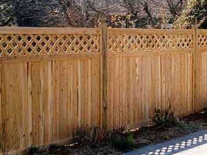 Wooden fence with diamond lattice top.