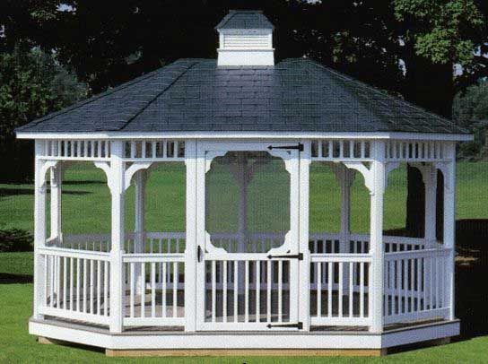 White octagonal gazebo with a dark roof in a grassy yard.