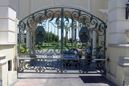 Ornate green wrought iron gates at a gated entry.