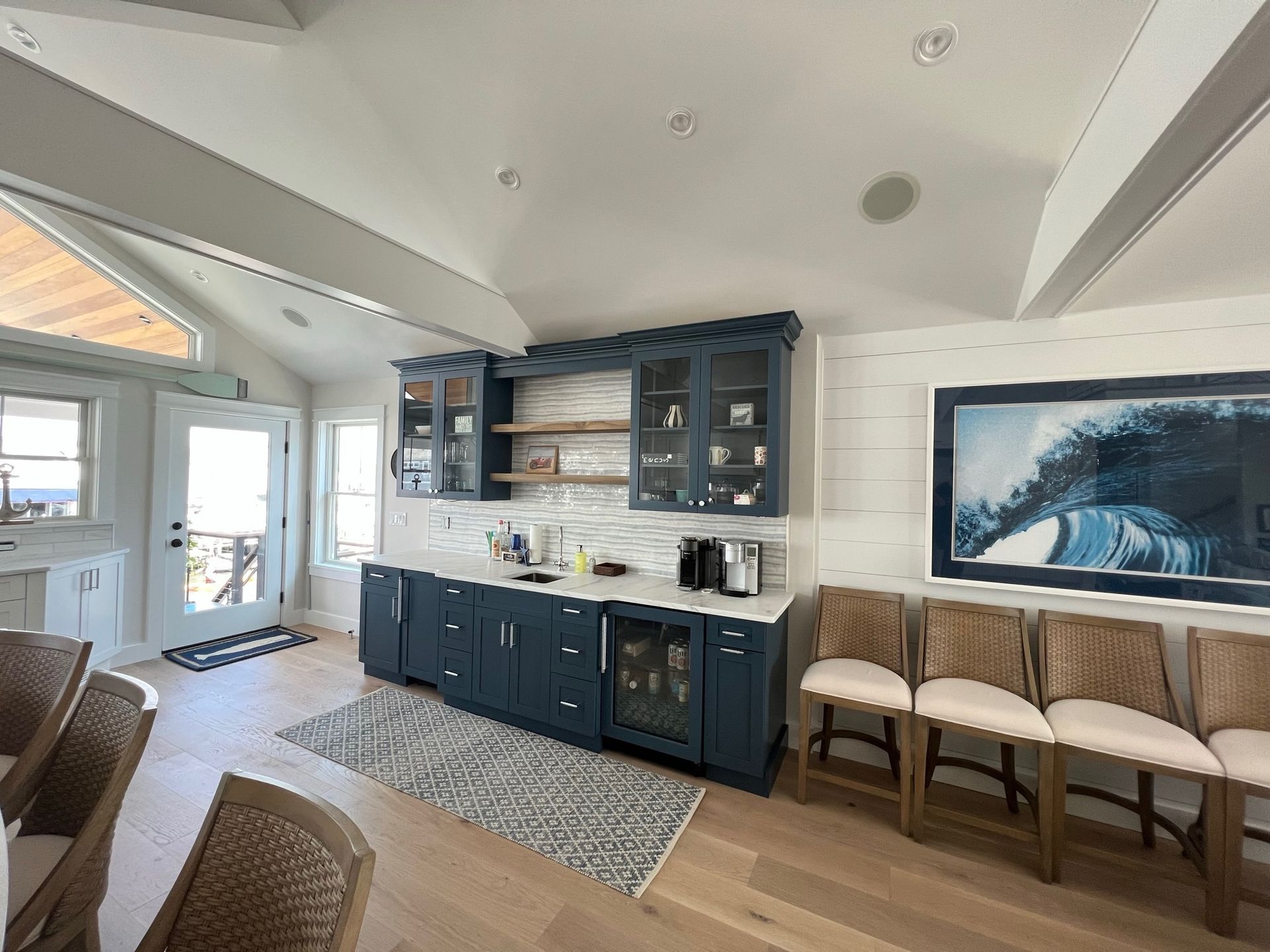 A modern blue bar area in a brightly lit room with a white countertop and seating.