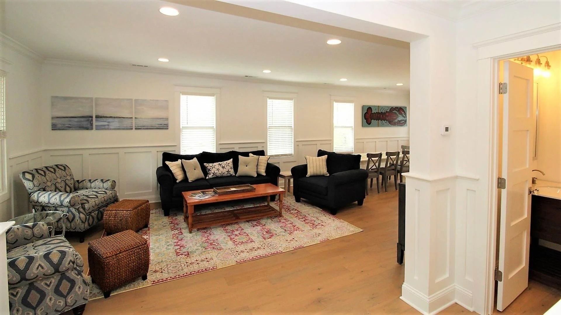 Living room with blue sofas, patterned armchairs, and a wooden coffee table.