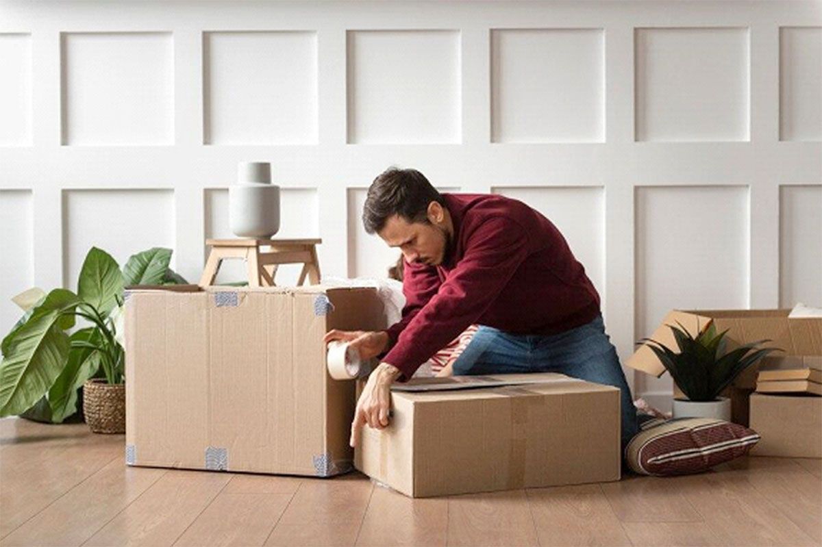 A man packing his things in a box before moving