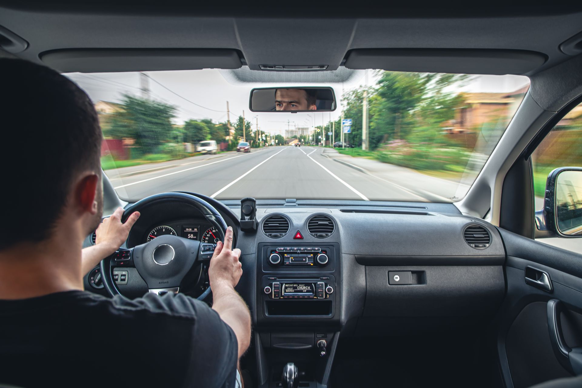 a man is driving a car down a road