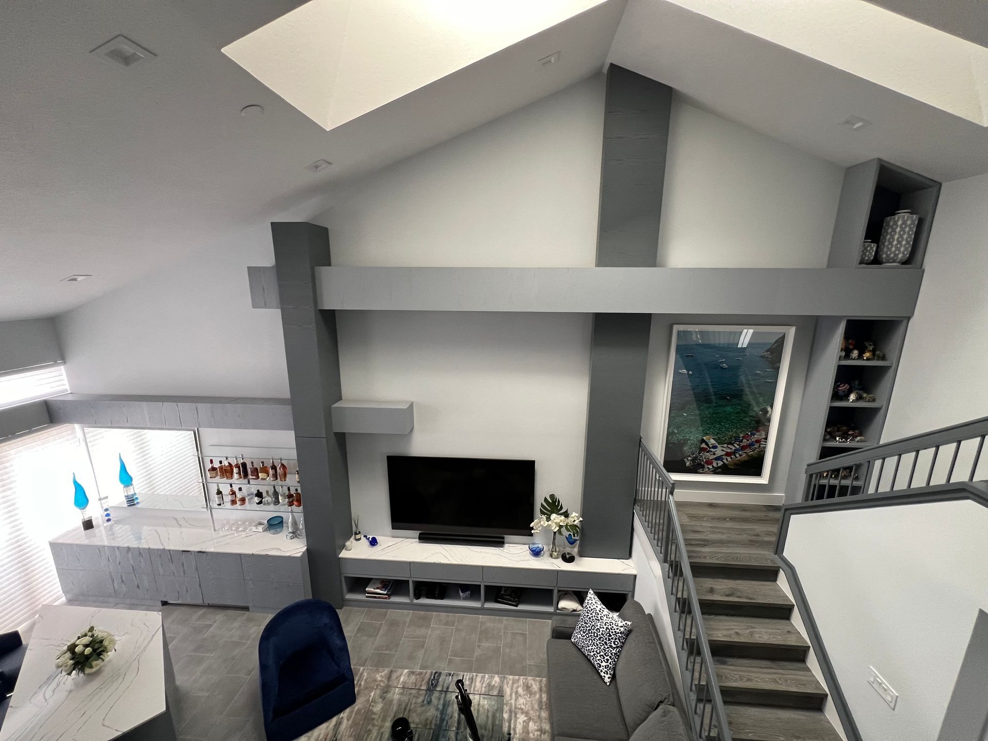 an aerial view of a living room with stairs and a flat screen tv