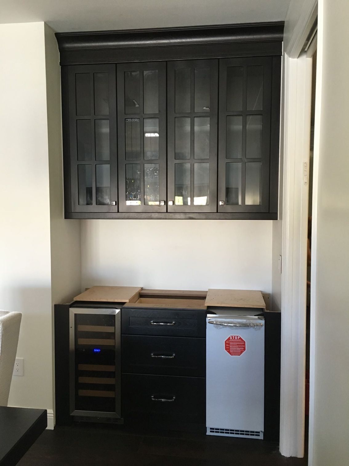 a kitchen with black cabinets and a wine cooler