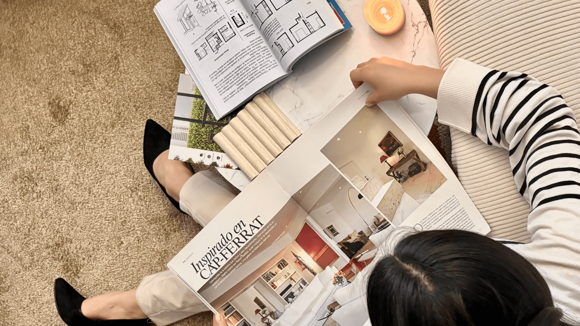 Person holding blueprints, looking at modern house exterior.