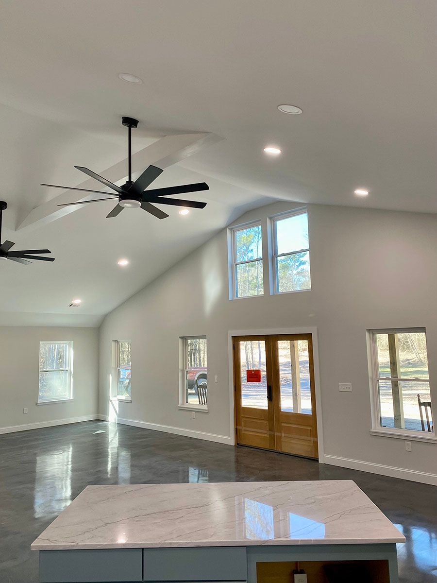 A large room with a ceiling fan and a marble counter top
