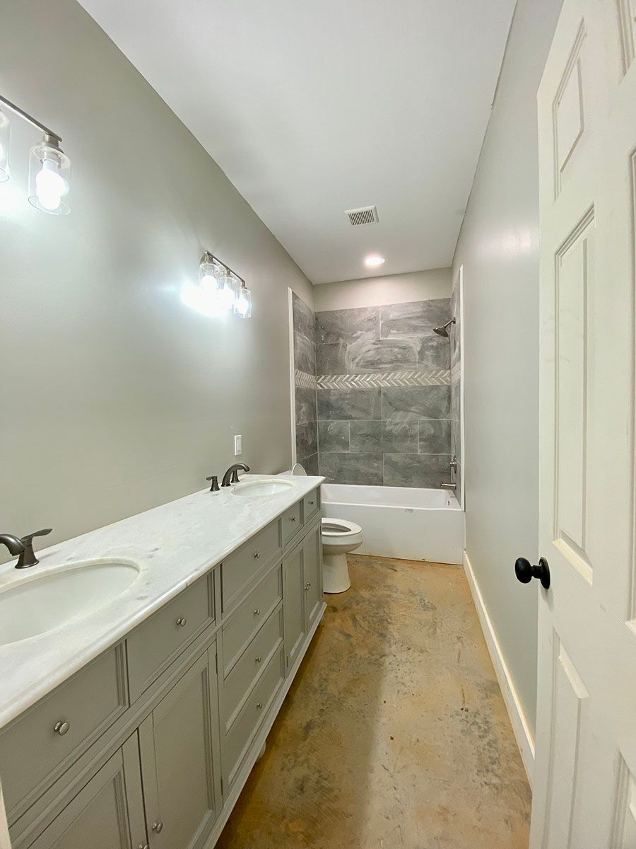 A bathroom with two sinks, a toilet, and a bathtub