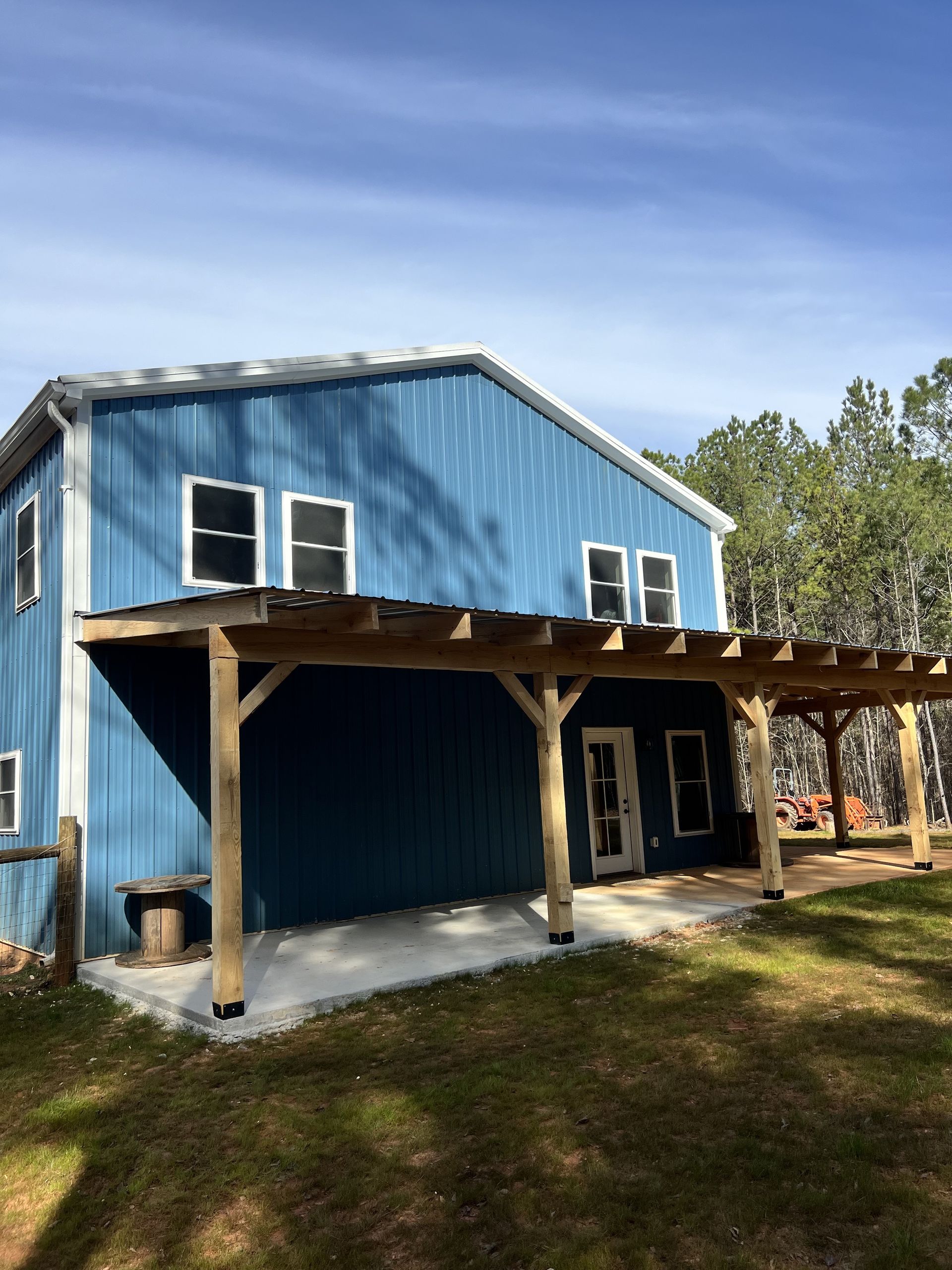 A blue house with a pergola on the side of it