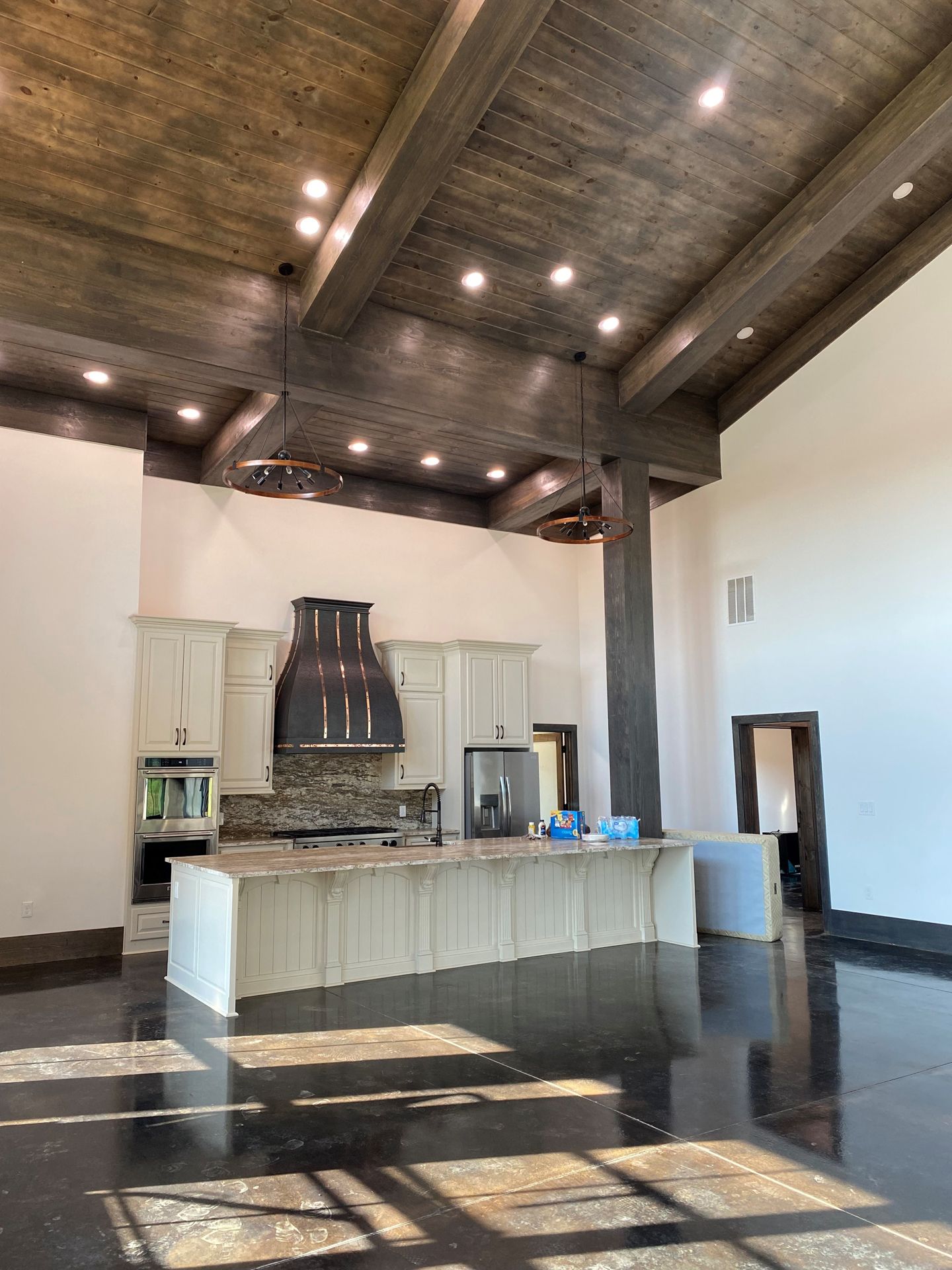 A large kitchen with a wooden ceiling and a large island