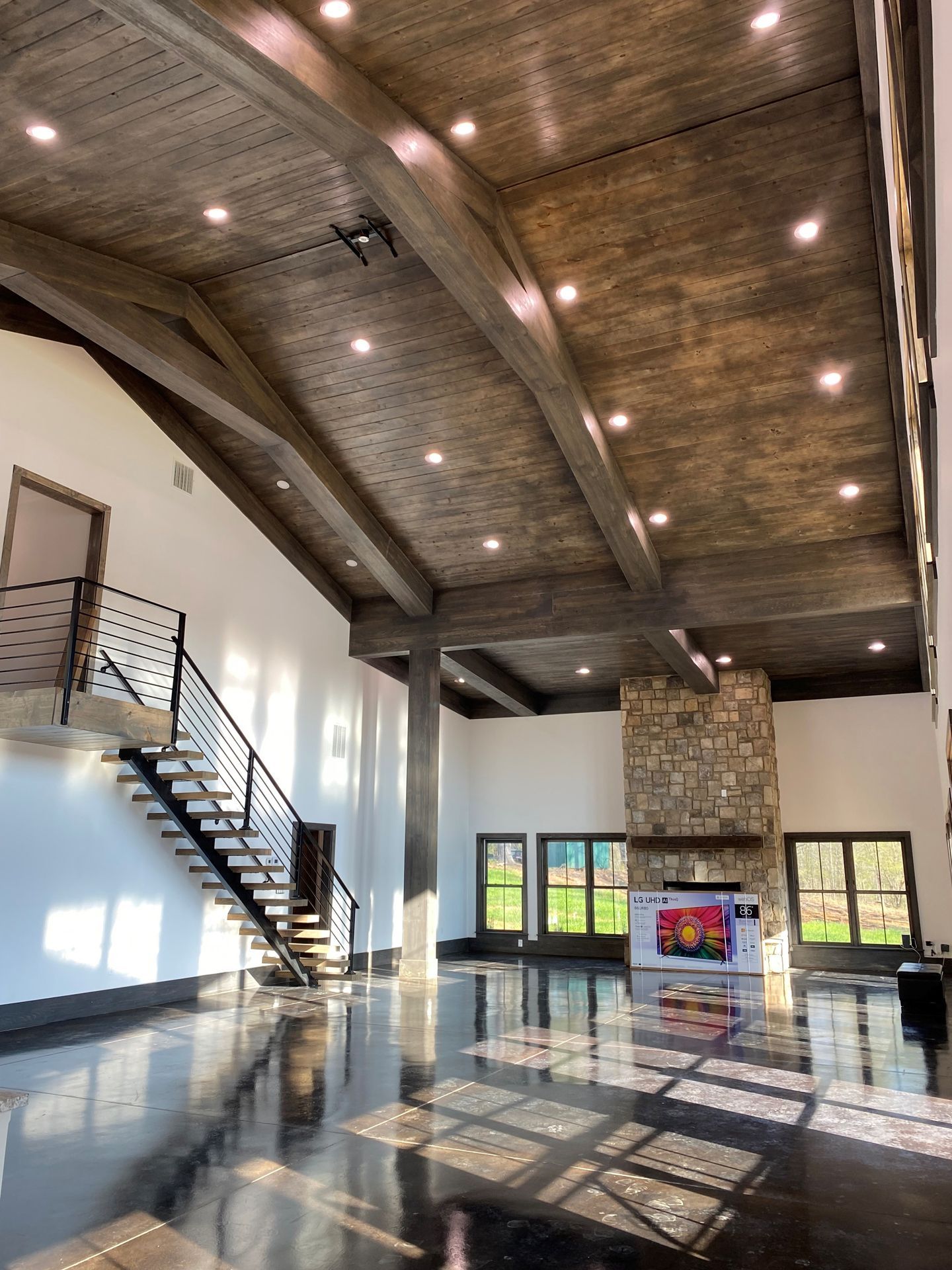 A large room with a staircase and a fireplace