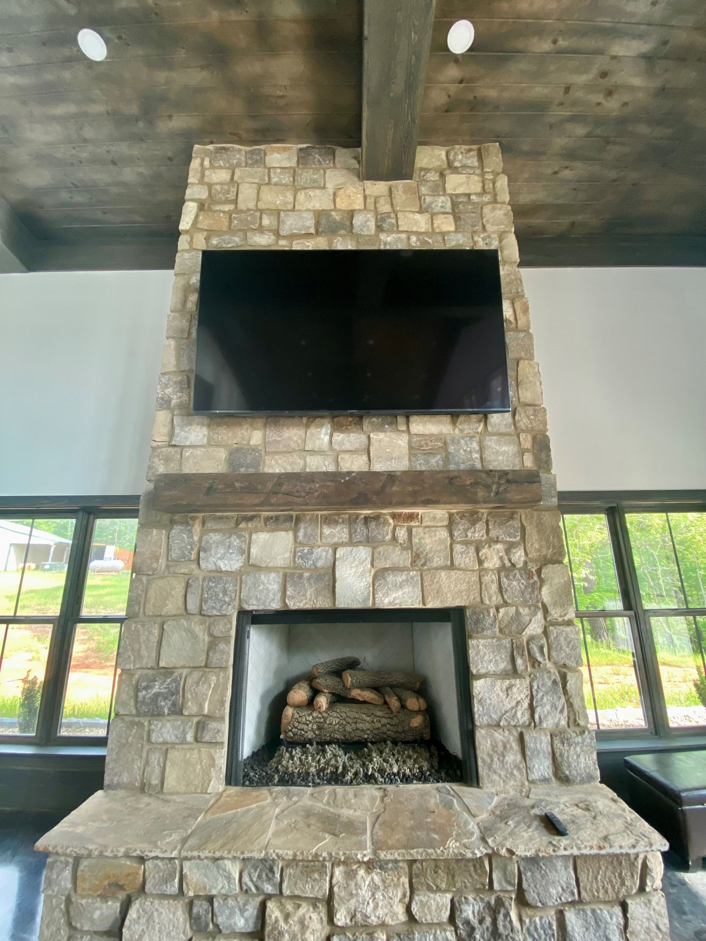 A stone fireplace with a flat screen tv mounted above it