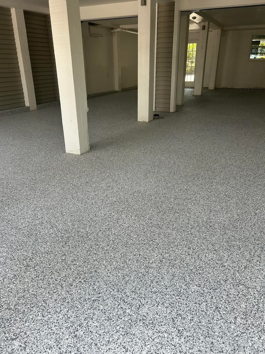 A garage with a concrete floor and white pillars.