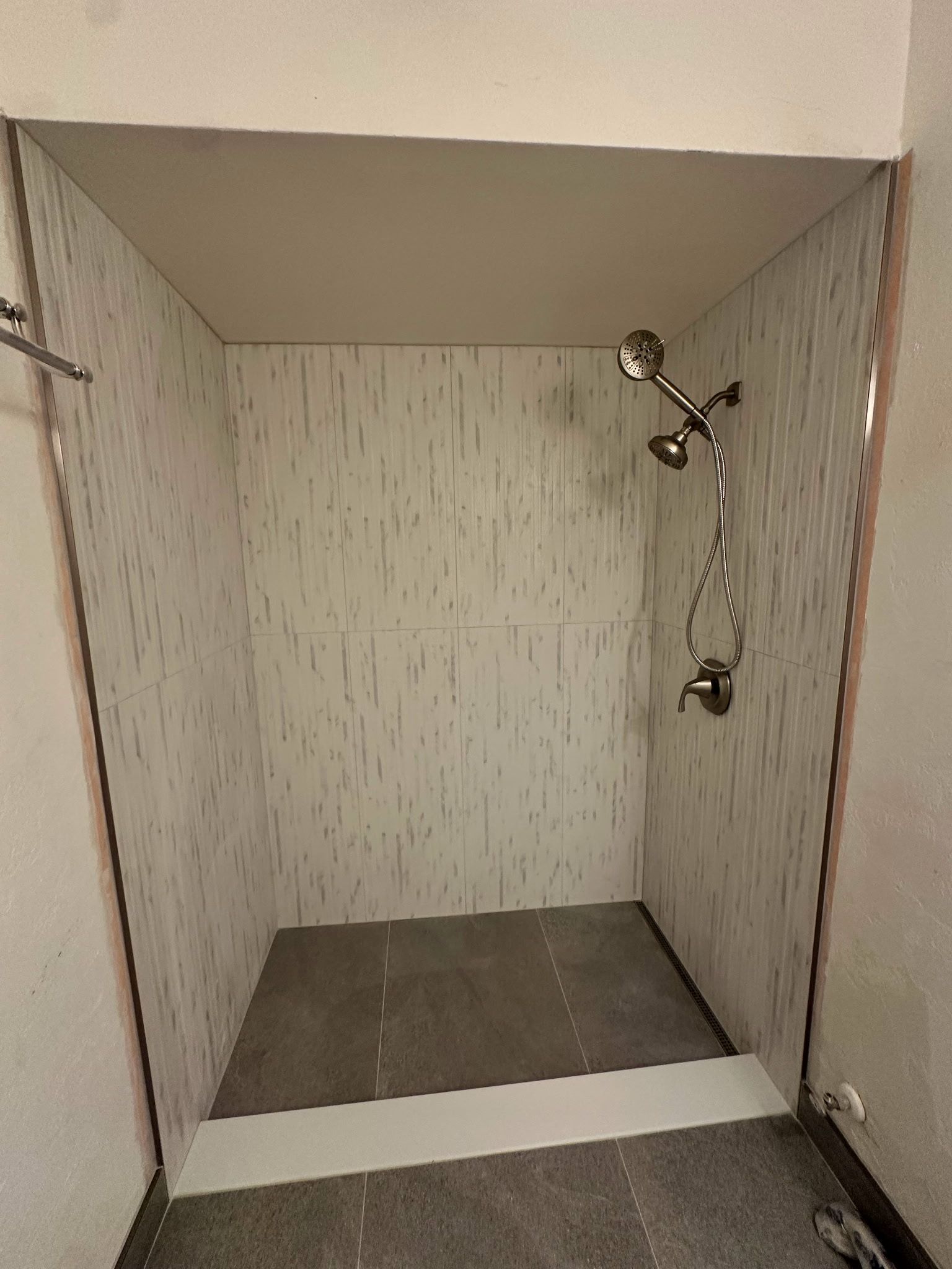 A bathroom with a walk in shower and two shower heads.