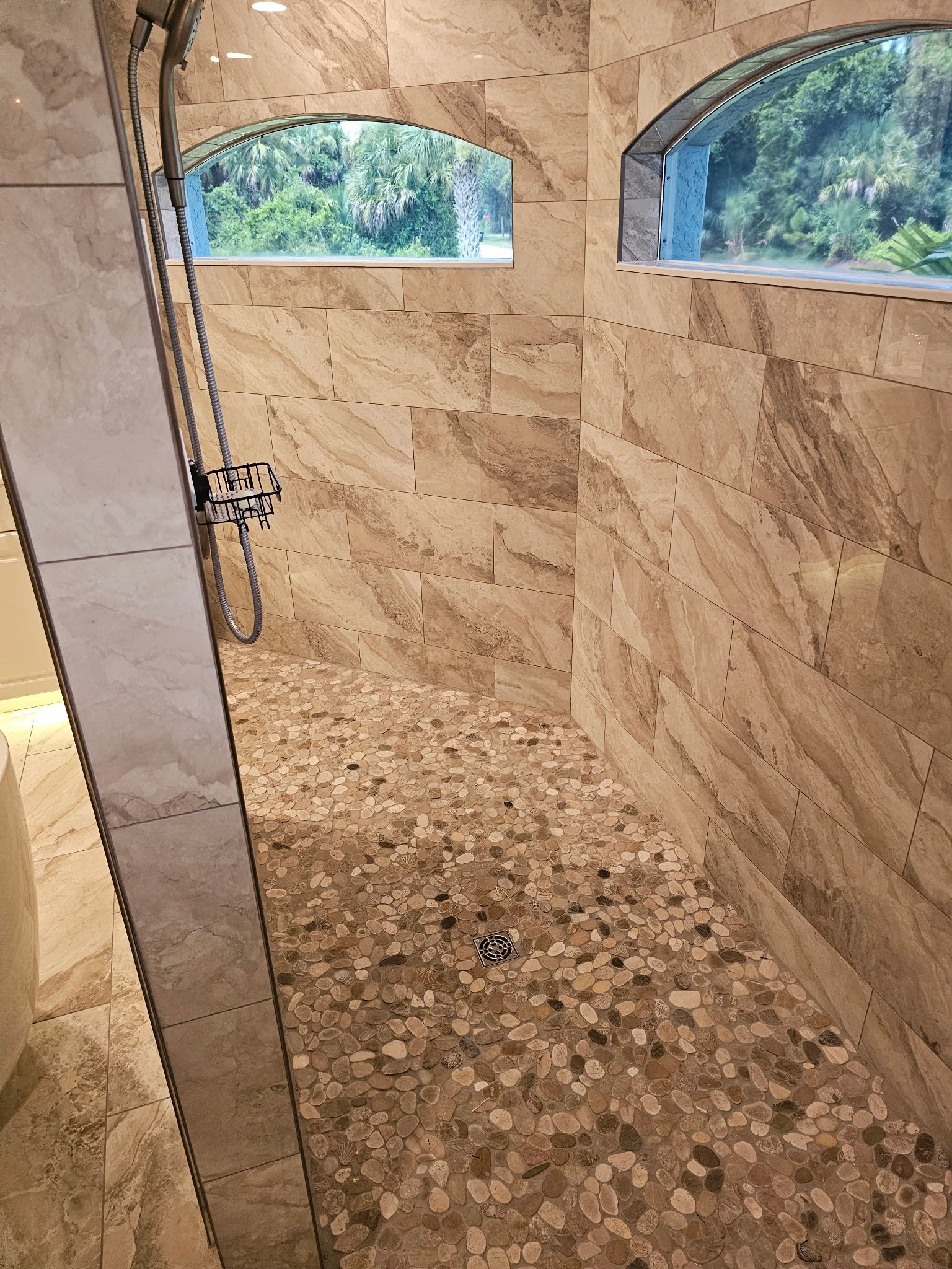 A bathroom with a walk-in shower and a window.