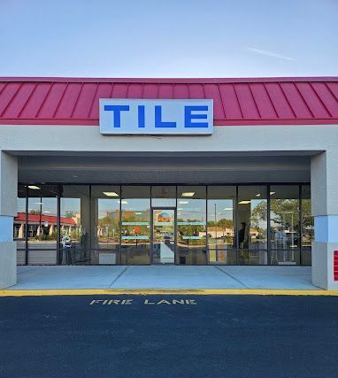 The front of a tile store with a red roof.