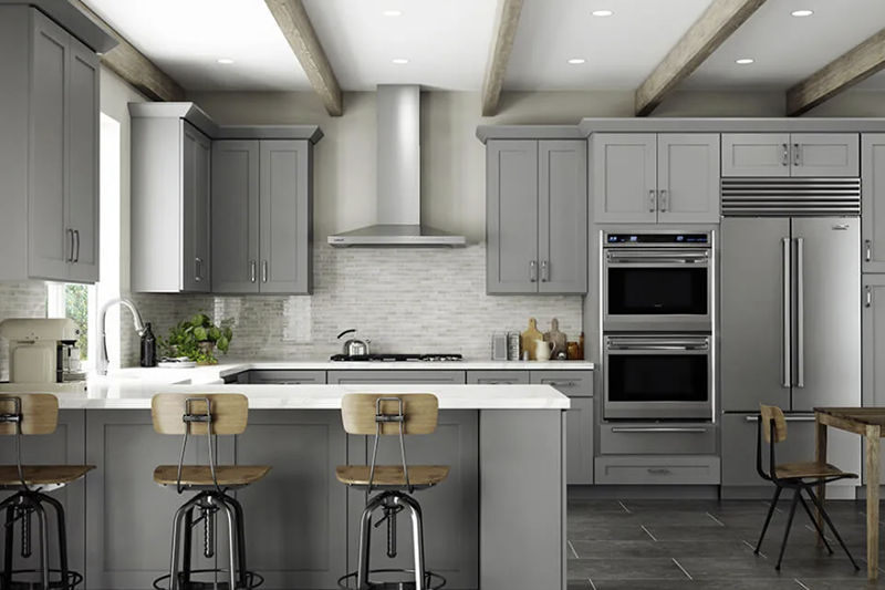 Modern gray kitchen with island, bar stools, stainless steel appliances, and bright recessed lighting.