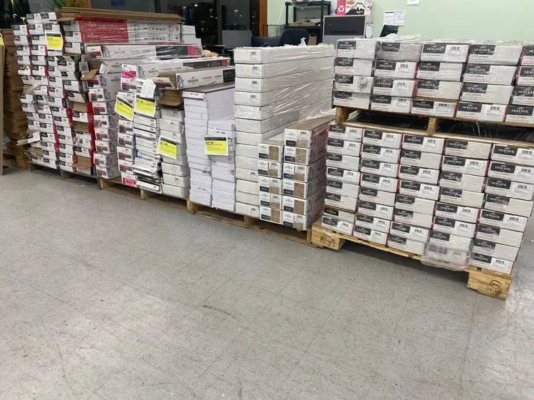 Pallets of flooring boxes stacked in a store.