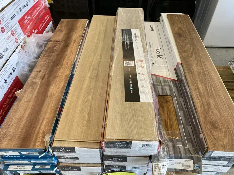Boxes of wood flooring in various colors, stacked on a pallet.