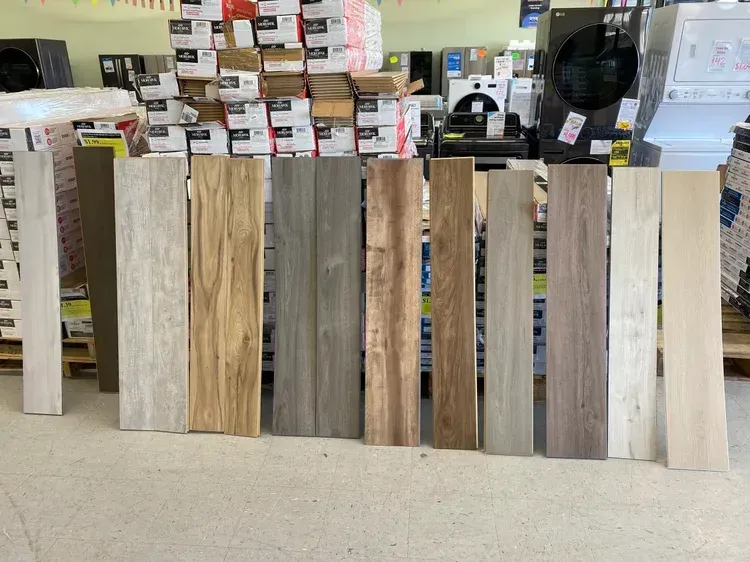 Various wood-look tile samples displayed in a store, showcasing different colors and textures.