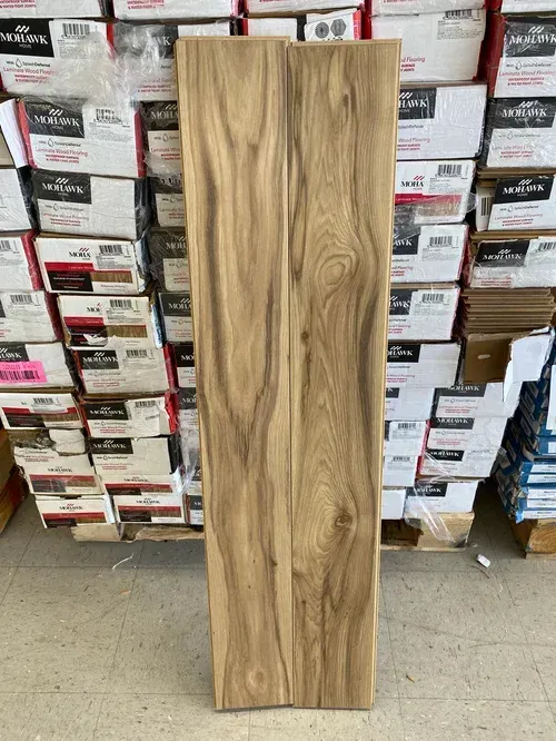 Two wood planks with natural wood grain, standing vertically in front of stacked boxes.