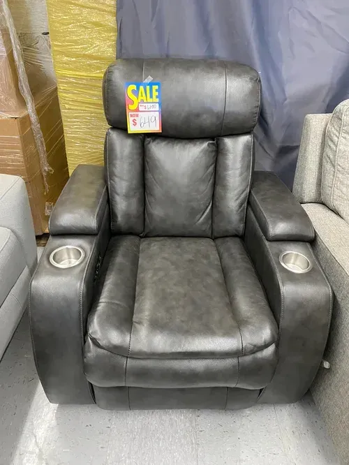 Gray leather recliner with cup holders, sale tag attached.