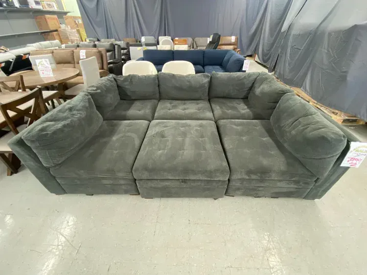 Gray modular sectional sofa in a warehouse setting.