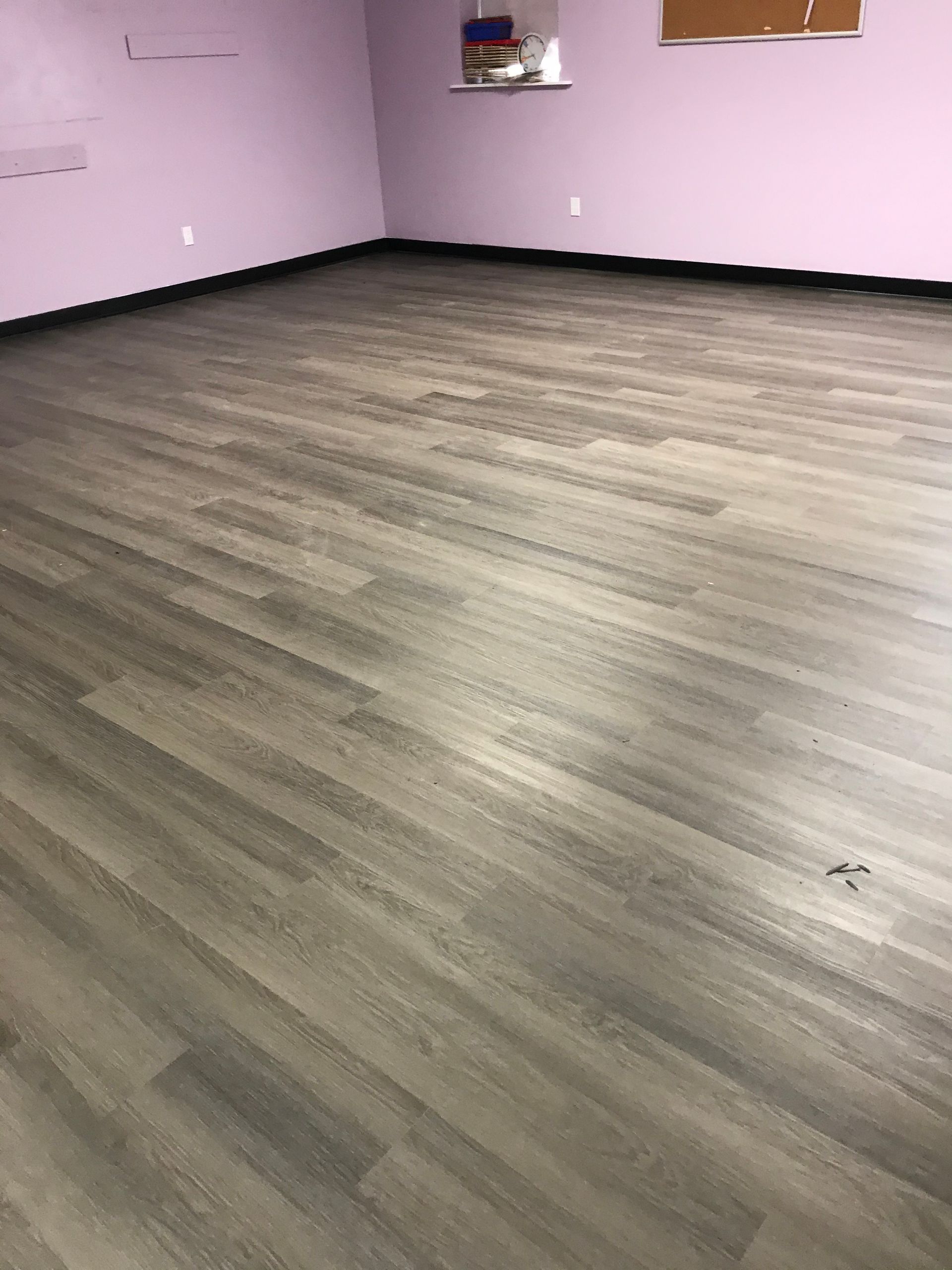 Empty room with pink walls and wood-look flooring